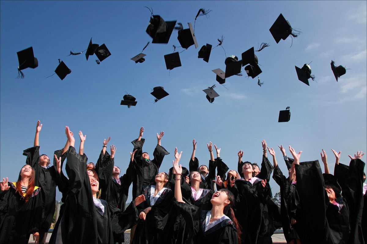 Graduates throwing their caps in the air after the ceremony